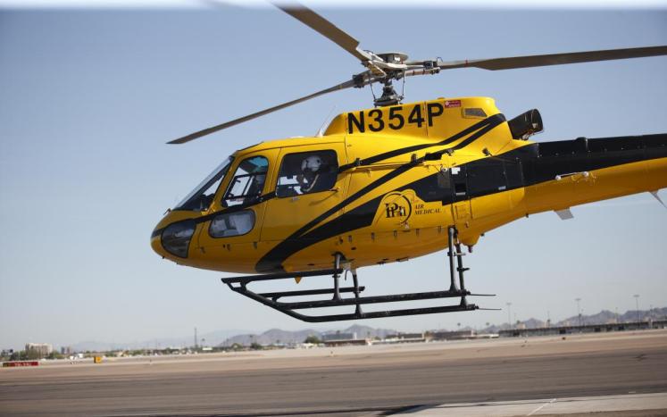 Photo of yellow PHI Air Flight Helicopter